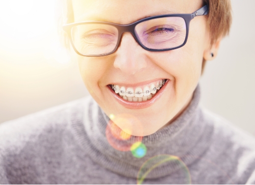 Female with glasses smiling with braces